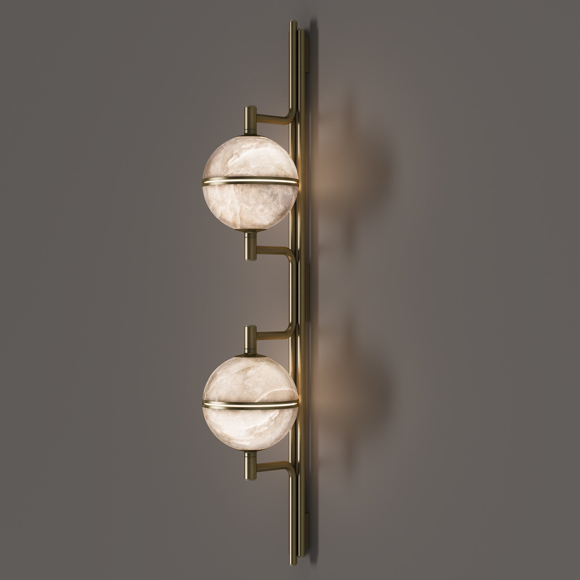 Andros II Wall Lamp Side view of the andros ii wall lamp in brushed brass with two illuminated alabaster spheres mounted on a vertical cream lacquered bar.