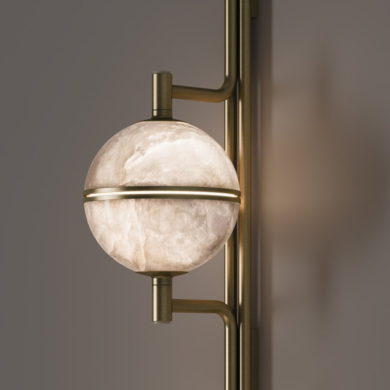 Andros II Wall Lamp Close-up detail of a single illuminated alabaster sphere on the andros ii lamp, highlighting the brushed brass horizontal band and natural stone texture.
