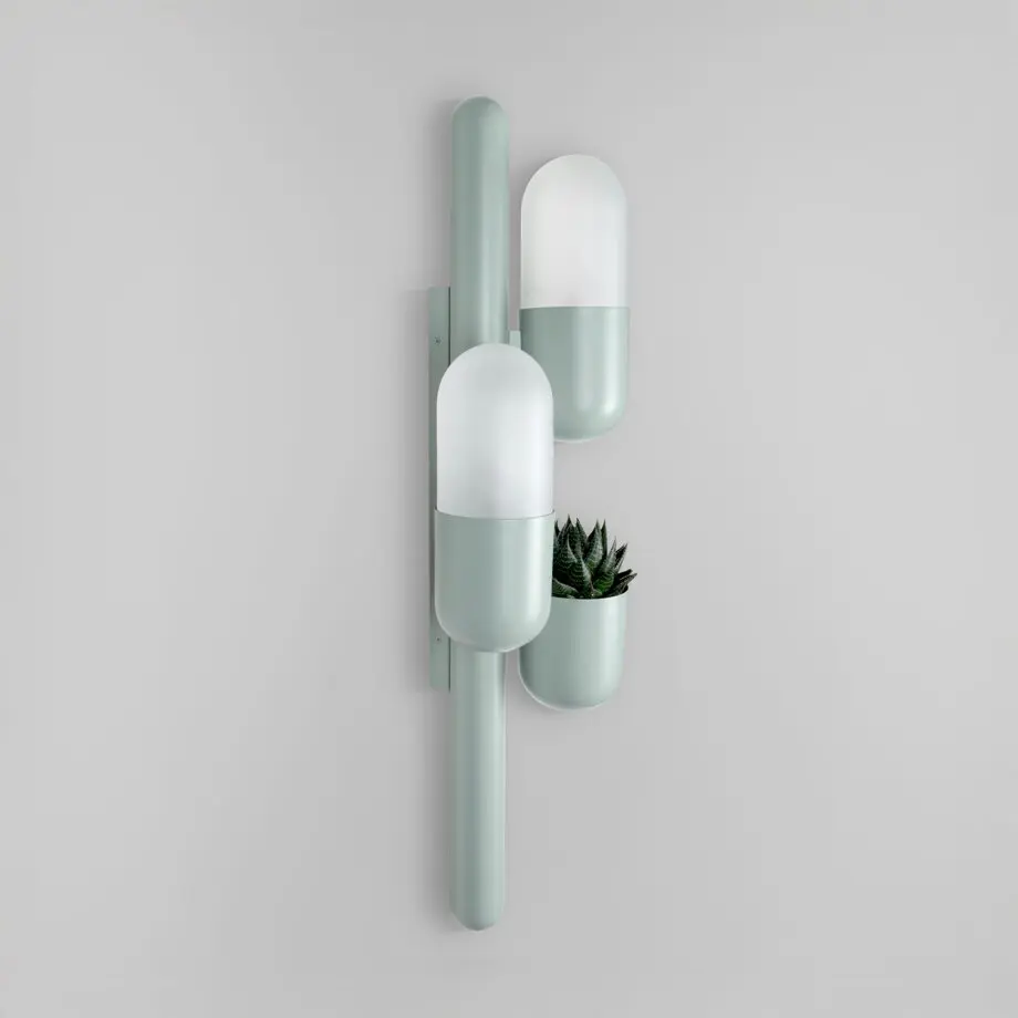 Cactus wall lamp lacquered in cement gray, with opal glass and a succulent plant, shown from the side with the lights turned off.
