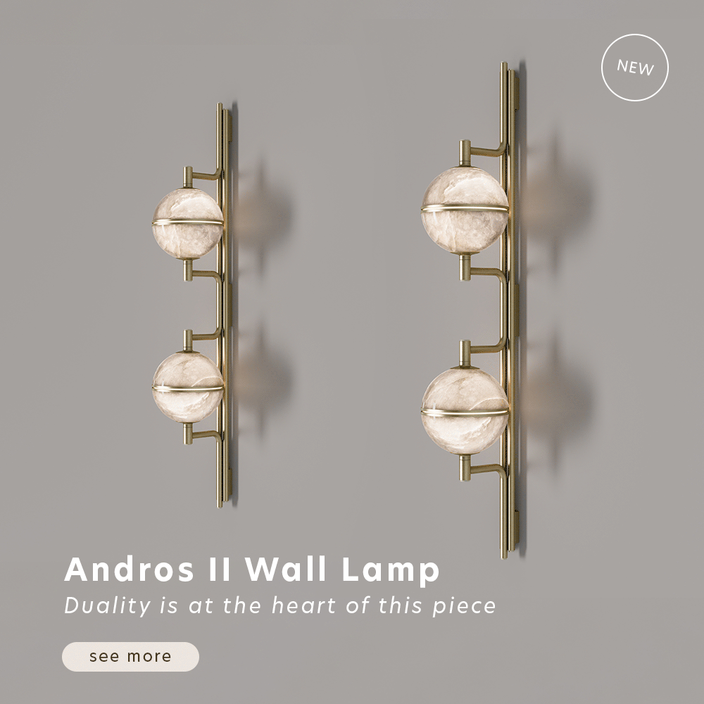 Animated image showcasing two andros ii wall lamps by creativemary, turning lights on and off, mounted side-by-side on a muted gray wall. Each lamp features a sleek, vertical brushed-brass spine that serves as a minimalist anchor. Attached to the spine are two glowing, spherical alabaster lampshades that emit a warm, translucent light, highlighting the natural stone’s unique veining. The lamps appear to subtly shift angles, showcasing their sculptural silhouette, cast shadows, and modern "wall jewelry" design.